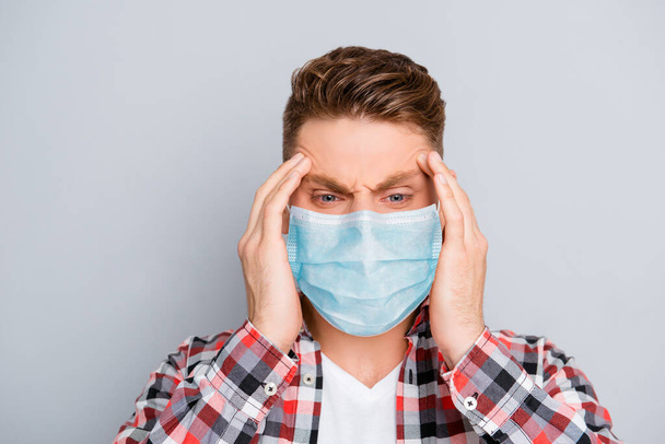 Portrait of ill sick young man in shirt wear medical safety face mask, touching his head feeling pain influenza respiratory disease symptom temperature cold, corona virus pandemic 2020 concept - Photo, Image