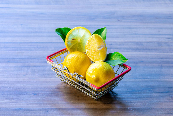 Cesta de supermercado con hoja verde y limón
 - Foto, imagen