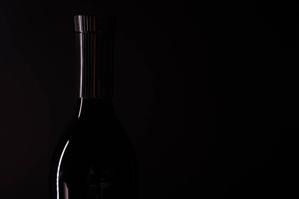 Empty bottle on black background. Bottle silhouette - Zdjęcie, obraz