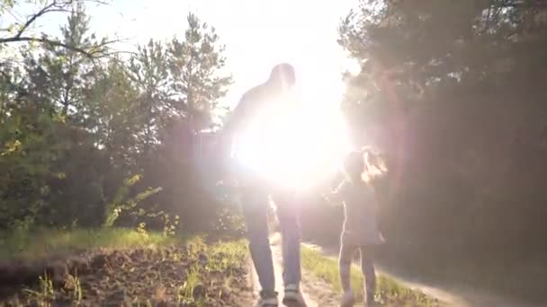 Old happy grandfather, little fun granddaughter walking on forest path together - Footage, Video
