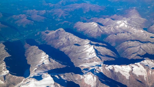 Alpok, kilátás a hegyekre a repülő ablakából. Földhajlítás és természeti koncepció. - Fotó, kép