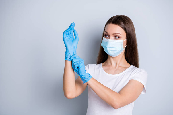 Photo of citizen responsible lady keep social distance crowd people hospital examination put on gloves hundred per cent protection concept wear face mask isolated grey color background - Foto, immagini