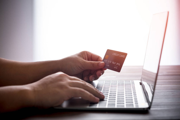hand holding credit card over laptop computer, online shopping concept - Fotoğraf, Görsel