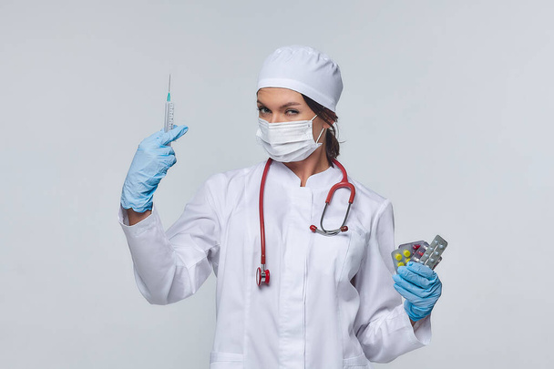 Medical concept of a female doctor in a white coat with a stethoscope, doctor. A female hospital worker looks at the camera and smiles, Studio, White background - Photo, image
