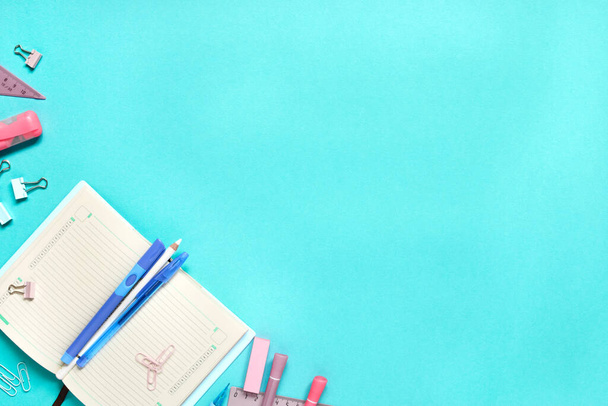 Colorful school suplies against light blue background with copy space. Back to school concept, top view. - 写真・画像
