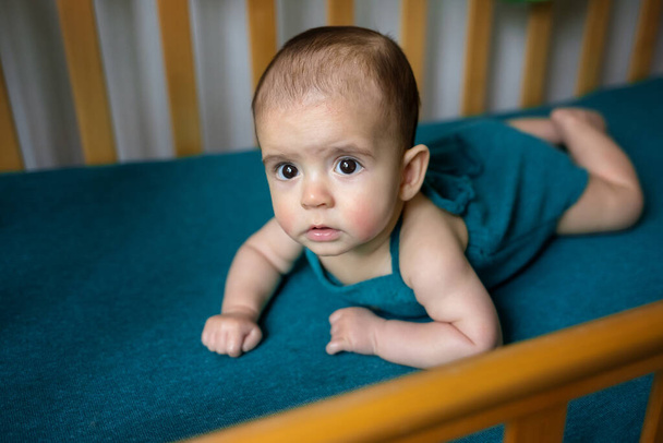 Leuke pasgeboren baby op een blauwe deken. Baby in zijn bed. Close-up portret van pasgeboren baby. Babygoederen verpakkingssjabloon. Kinderkamer. Medisch en gezond concept. - Foto, afbeelding