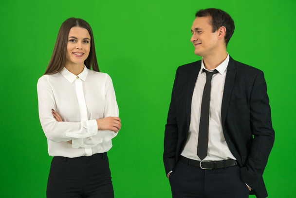 Бизнесмен и деловая женщина стоят на зеленом фоне
 - Фото, изображение