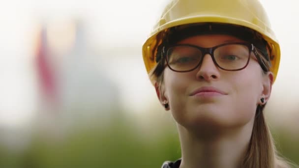 Kafkas kadın inşaat mühendisi portresi başını sallıyor. Gözlüklü ve sarı şapkalı kadın. - Video, Çekim