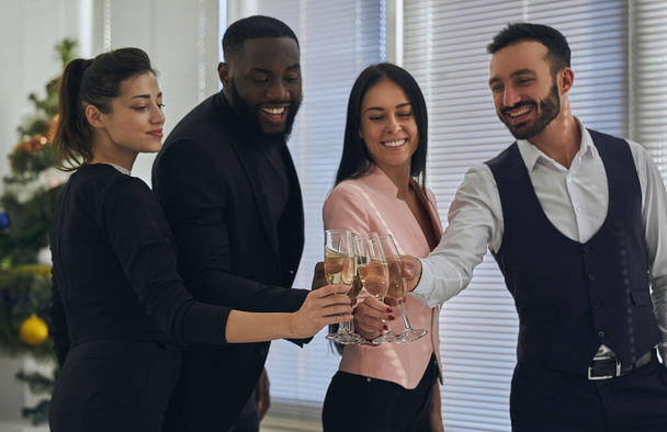 The four business people drinking a champagne - Zdjęcie, obraz