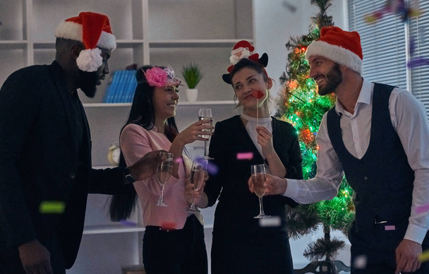 Az üzletemberek pezsgőt isznak a karácsonyfa hátterében - Fotó, kép