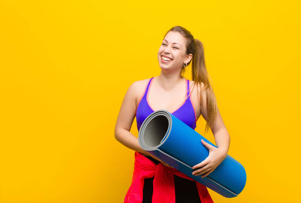 young blonde woman with a yoga mat. sport concept - Foto, afbeelding