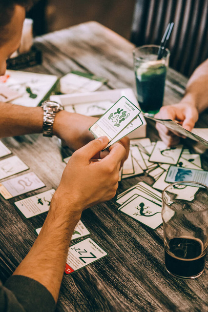 a group of friends plays board games in a cafe and drinks - 写真・画像