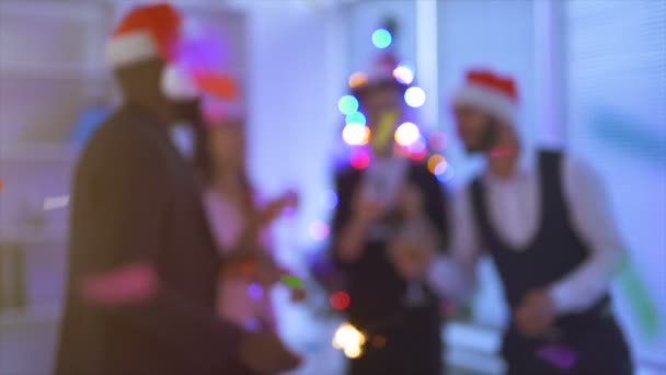 Čtyři lidé pijící šampaňské u vánočního stromku v kanceláři. zpomalený pohyb - Záběry, video