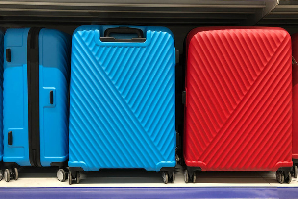 крупним планом зображення двох великих валіз червоного і синього кольору на полиці. Чекаю на подорож. Концепція подорожей
.  - Фото, зображення