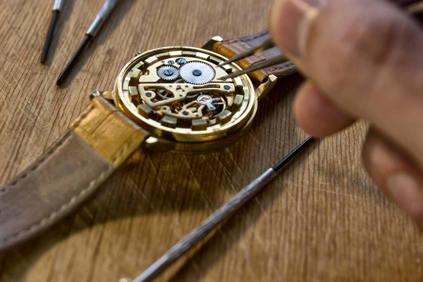 ωρολογοποιός επισκευάζει τα μηχανικά ρολόγια στο εργαστήριό του - Φωτογραφία, εικόνα