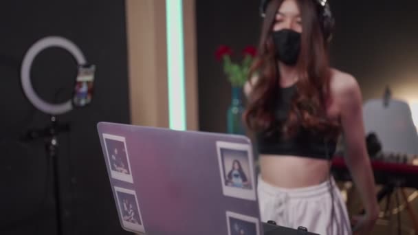 Asijská žena dj nosit černou masku těšit hudbu, edm hudební party, živé vystoupení, Asijská žena dj mix hudba v nočním klubu, anti-karanténa covid-19, nezávislá žena, internet live streaming - Záběry, video