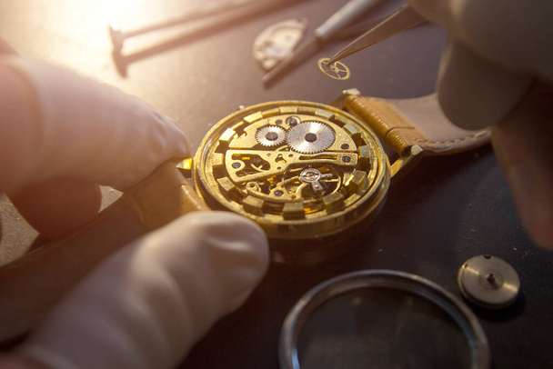 ωρολογοποιός επισκευάζει τα μηχανικά ρολόγια στο εργαστήριό του - Φωτογραφία, εικόνα