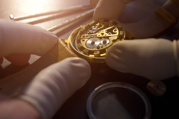 Uhrmacher repariert die mechanischen Uhren in seiner Werkstatt - Foto, Bild