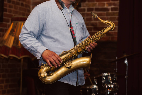 man die saxofoon speelt in jazzrestaurant - Foto, afbeelding
