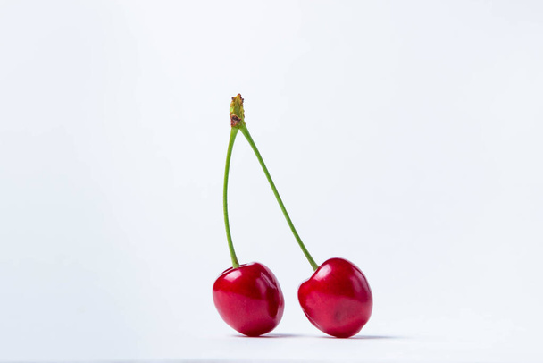 Pair of red cherries. Ripe juicy cherries on a white background. Only cherries on a white background - Foto, Imagem
