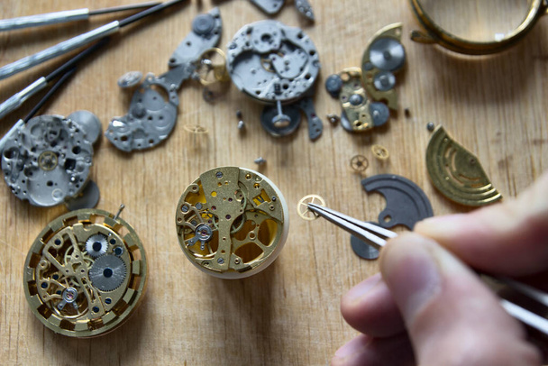 Вартовий ремонтує механічні годинники у своїй майстерні
 - Фото, зображення