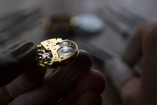 horlogemaker repareert de mechanische horloges in zijn werkplaats - Foto, afbeelding