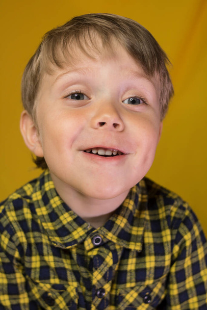 Μωρό με ένα απίστευτο χαμόγελο σε κίτρινο φόντο - Φωτογραφία, εικόνα