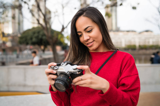 Portrait of young photographer woman using a professional digital camera outdoors. Photography concept - Fotó, kép