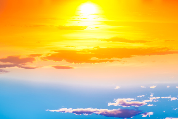 太陽の青とオレンジの劇的な雲と太陽の光線と日没の空 - 写真・画像