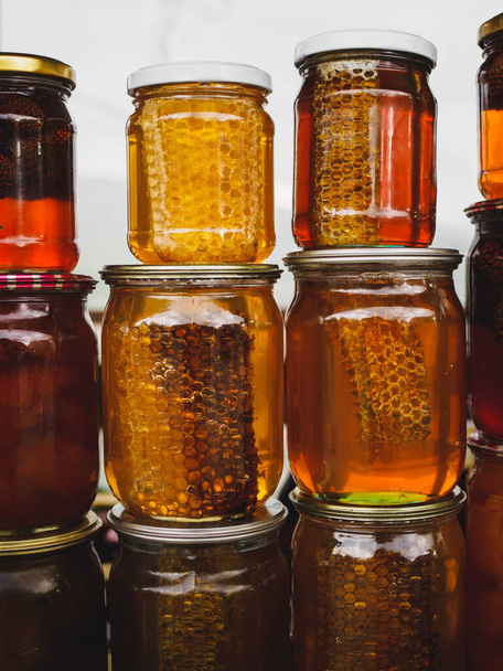 Coloridos peines de miel y miel y diferentes conservas en frascos en el mercado local de cerca. Armenia, Cáucaso
 - Foto, Imagen