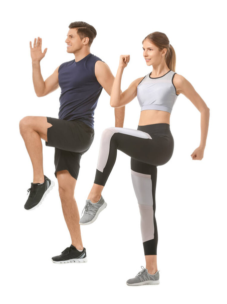 Sporty young couple training on white background - Foto, imagen