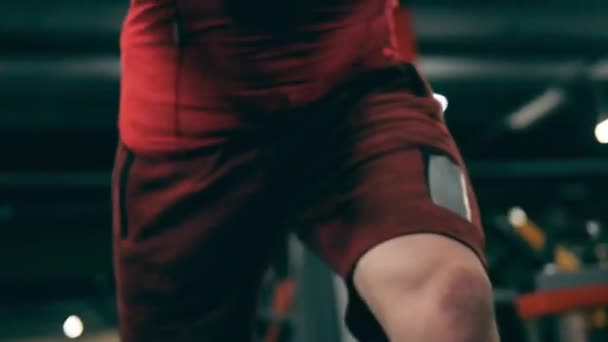 Male athlete is stretching arms with a fitness machine - Materiał filmowy, wideo