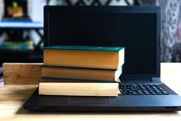 Régi könyvek a laptopon. Az otthoni oktatás fogalma - Fotó, kép