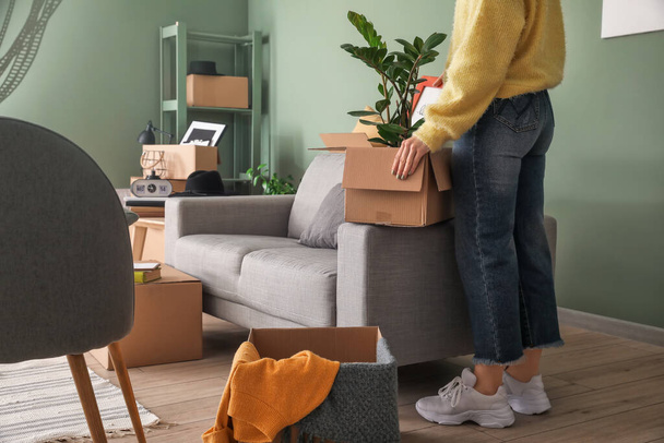 Женщина с вещами в картонных коробках в день переезда
 - Фото, изображение