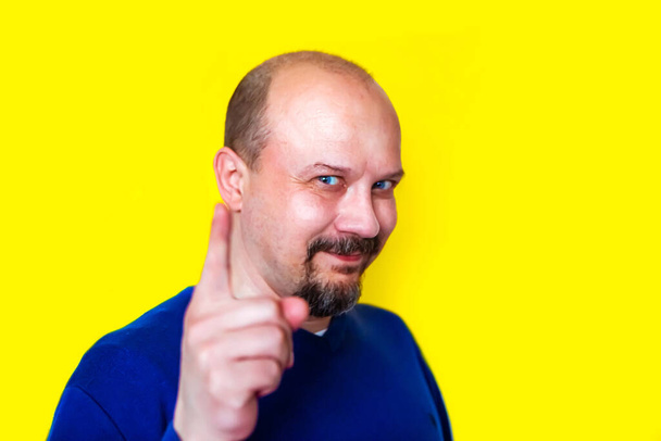 man with a beard and mustache, pointing at the camera on bright yellow background - Photo, Image