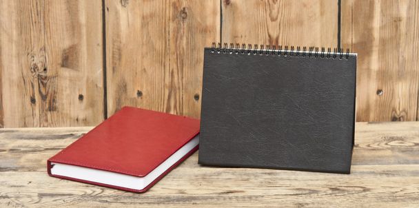 desk calendar with red leather note book on wood table - Fotó, kép