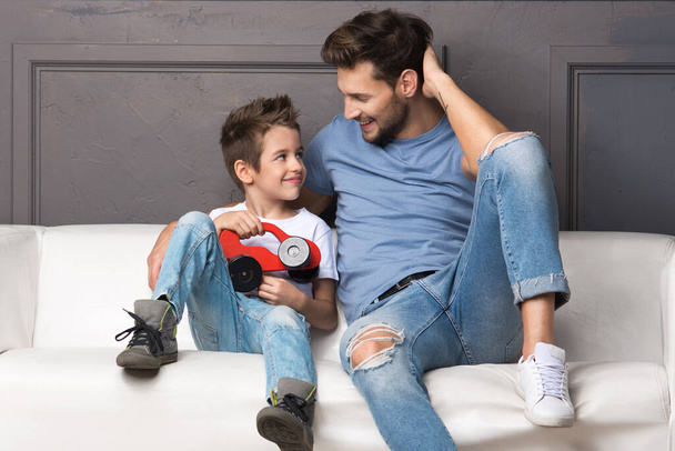 Father and son are sitting on the couch - Foto, immagini