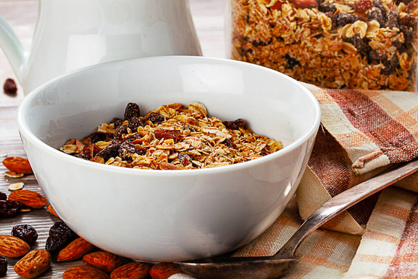 Muesli in the bowl on wooden table. Healthy breakfast composition. - Фото, зображення