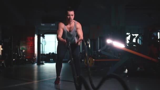 attractivel athletic fitness male exercising ropes in modern gym - Materiaali, video