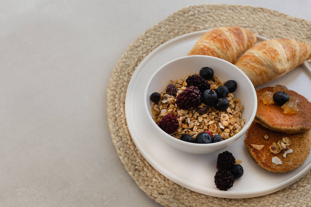 Здоровый завтрак концепции. Гранола с ягодами, круассанами и
 - Фото, изображение
