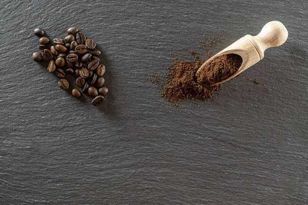 Cafe coffee background. Espresso beans for food, drink caffeine breakfast on black. Brown roasted coffee seeds isolated for energy mocha, cappuccino ingredient. Copy space, top view - Photo, Image