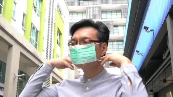 Asian Chinese businesswoman wearing medical face mask. Protection from coronavirus or pandemic. Lifestyle or new normal concept. - Filmati, video