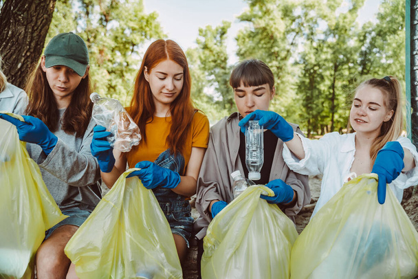 Egy csapat aktivista gyűjti a műanyag hulladékot a parkban. Környezetvédelem. - Fotó, kép