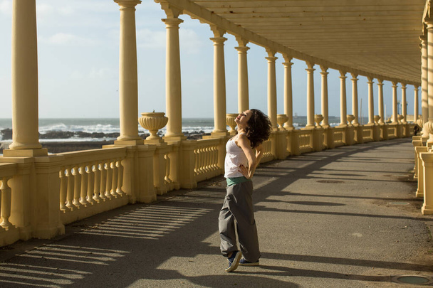 Mooie vrouw dansen van de zee promenade in Porto, Portugal.  - Foto, afbeelding