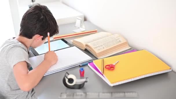 ストレスのある子供が宿題をするストレスのある行動で宿題をする勉強台の男の子ストレスのある顔で宿題をする怠惰な少年. - 映像、動画