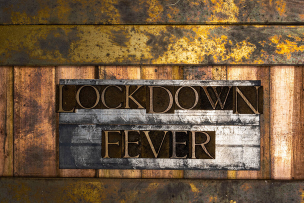 Φωτογραφία από πραγματικά αυθεντικά δακτυλογραφημένα γράμματα σχηματίζοντας Lockdown Fever κείμενο σε vintage υφή ασημί grunge χαλκού και χρυσό φόντο - Φωτογραφία, εικόνα