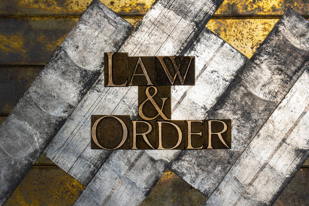 Foto van echte authentieke letters vormen Law and Order tekst op vintage getextureerd zilver grunge koper en goud achtergrond - Foto, afbeelding