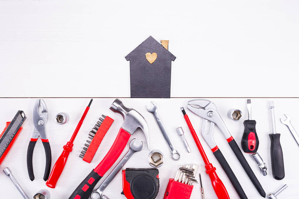Repair tools as a foundation for a home on a light background. - Фото, изображение