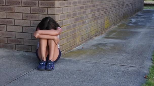 Üzgün genç kız (9-10 yaş) bir kadın tuvalet binasının köşesinde ağlıyor. - Video, Çekim