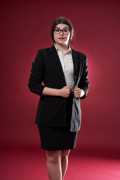Closeup of an attractive businesswoman on red background - 写真・画像